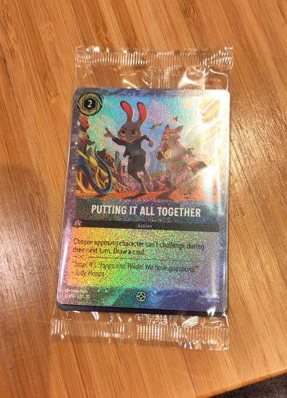 A cinema promotional version of the card "Putting It All Together". It's very sparkly and enveloped in a small plastic package.