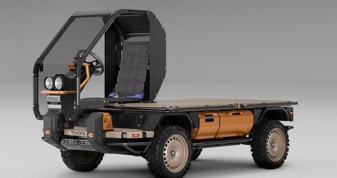 A prototype of a compact, open-air utility vehicle featuring a simple design with a flatbed, large tires, and a minimalistic cabin structure. The vehicle is primarily colored in black and orange, showcasing a modern yet rugged aesthetic.