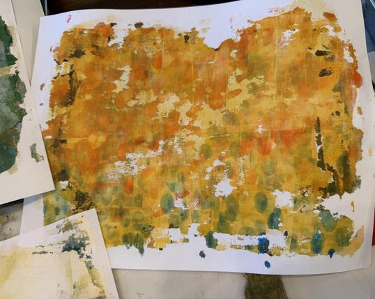 An abstracted patterns of colors on a white paper. Colors are gold, orange, blue-greens. Sort of looks like fall foliage.