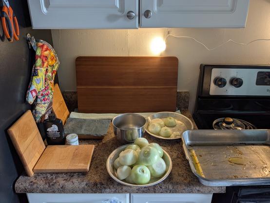 Image shows a kitchen countertop with cutting boards and chopped onions ready to roast.
La imagen muestra una encimera de cocina con tablas de cortar y cebollas picadas listas para asar.