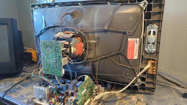 A Samsung CRT, with the back cover removed. The tube, neck board, and main boards are all visibile and dangerously exposed (yay hi voltage). This is a fairly unique set circa 2005 which supports digital (HDMI) inputs, and also features a native 16:9 aspect ratio and a super-thin tube design (about half the depth of most 32" CRTs). I really want to fix it but it's being a pain in the posterior.