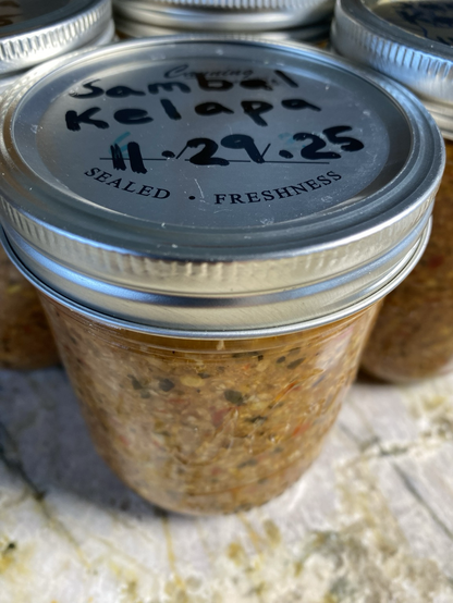 We are trying to see the looks of the jarred chilies and the lids. Sambal Kelapa 11-29-25 is written on the lids.