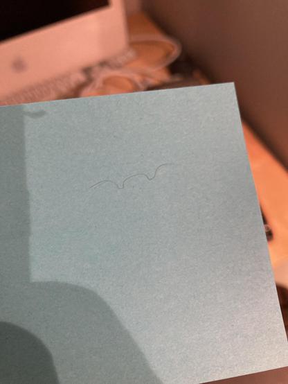 A blond pubic hair with two perfectly square ridges in it sits on top of a post-it note.