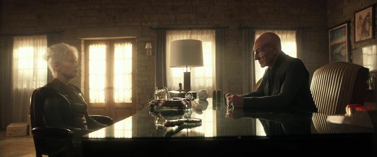 Picard speaks to Star Fleet Admiral Clancy in a charming office study.