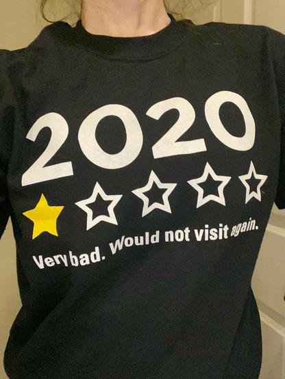 A black T shirt on a mannequin whose head, arms and lower torso you cannot see.  There is text on the T shirt.  The first line, at the top just says "2020."  The second line is five stars, the first of which is filled in with yellow, to indicate a rating of one star out of five.  The last line says "Very bad. Would not visit again."  It was a commentary on the COVID pandemic. Even though the pandemic is officially over, I think there are plenty of reasons why this shirt could easily be adapted as commentary on 2025.