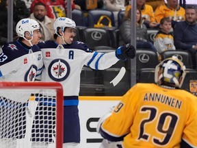 Winnipeg Jets centre Gabriel Vilardi (left) celebrates his goal with Mark Scheifele as Predators goalie Justus Annunen looks on in Nashville, Tenn. George Walker IV/The Associated Press