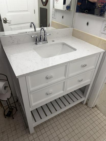 A white vanity
The side backsplash is colored
Sitting on white tiles