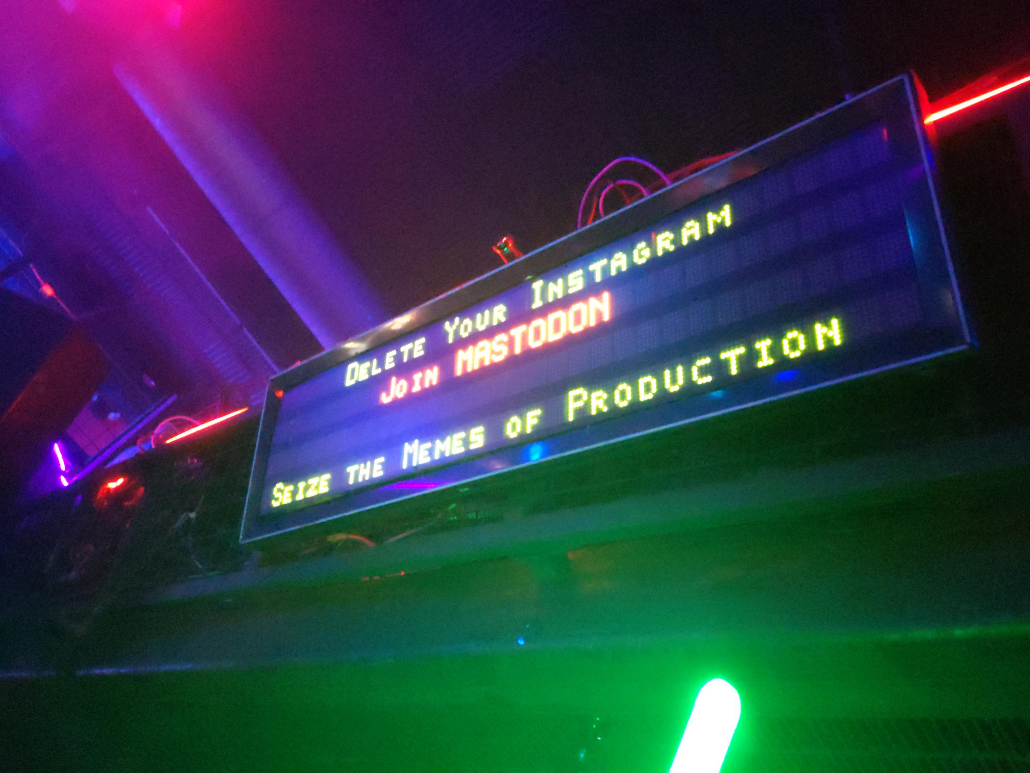 A digital sign that reads: Delete Your Instagram Join MASTODON Sieze the Memes of Production