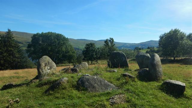 Four massive stones still standing ‘overlooking’ Loch Tay with two large fallen, & small boulders in the circle.