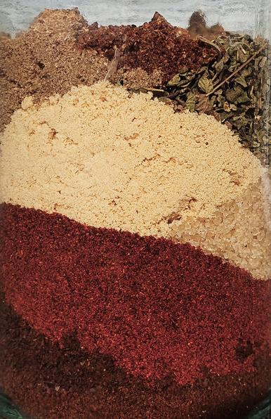 Gewürze und Kaffeepulver für den Rub in einem Glas geschichtet in der Optik von Erdschichten.