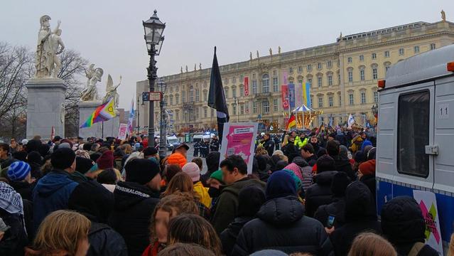 Bilder von der Demo gegen Rechtsextreme in Berlin. Menschen mit Regenbogenflaggen und Plakten.