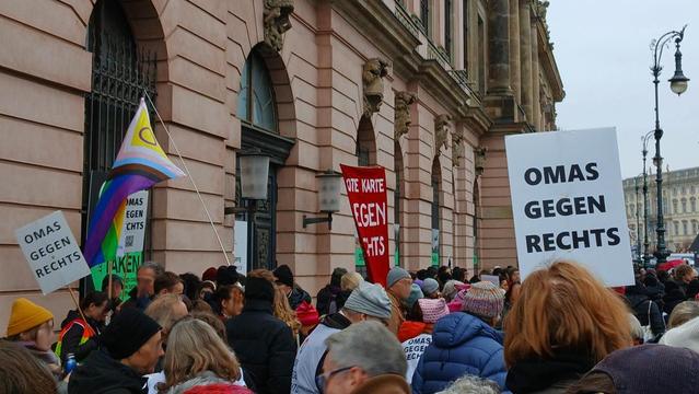 Bilder von der Demo gegen Rechtsextreme in Berlin. Menschen mit Regenbogenflaggen und Plakten.