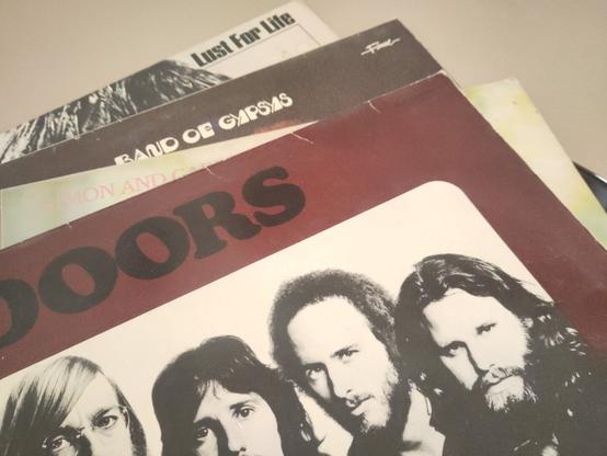 4 Übereinander gestapelte Schallplatten: Iggy Pop "Lust dir Life, Jimmy Hendrix "Band of Gypsies", Simon & Garfunkel "Greatest hits", The Doors "L.A. Woman.