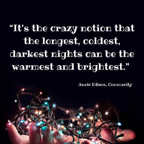 A black background with hands holding fairy lights at the bottom. In white writing above that, it says, "It's the crazy notion that the longest, coldest, darkest nights can be the warmest and brightest." Annie Edison, Community