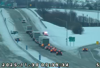 A car has spun out and his the center wall on I-65 north near US 231. Cars and trucks are in a single line to get around it. A police car is on the outside shoulder with emergency lights on.