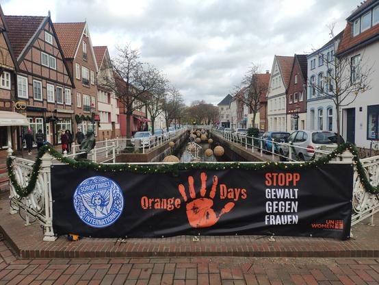 Blick auf den Kanal von Buxtehude mit Plakat zum Orangeday der Soroptimisten.