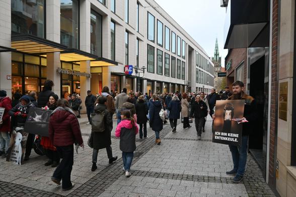 Aktivis stehen in der Innenstadt und halten Schilder mit Tieren darauf und Sprüchen wie "Kein Lammbraten" die Stadt ist sehr voll.