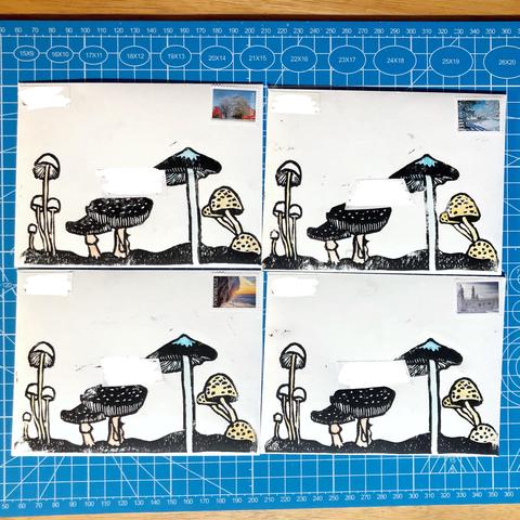 four enveloped laid out in a square, each envelop has a black linoprint of several types of mushrooms spread out along it's bottom edge. parts of the mushrooms have been painted in with watercolors.