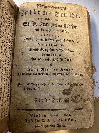 Tittelbladet i gulnet bok med gotiske bokstaver. Tittelen er «Christendommens lærdoms grunde, som indeholder om den striid, trængsel og arbeide som de christne haver uddragne saavel af de gamle lære-fædres skrifter, som de nuværende, samlet og rettet efter de enfoldiges forstand av Hans Nielsen Hauge». Utgivelsesår: 1800