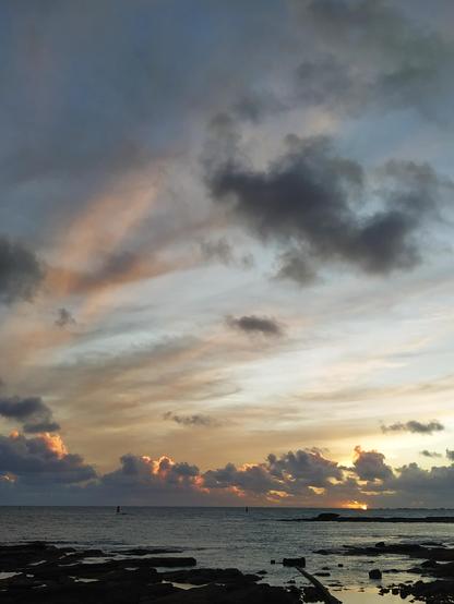 Coucher de soleil et lumière orangée dans les nuages, au-dessus de l'océan au Guilvinec