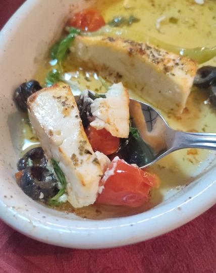 Überbackener Schafskäse mit Oliven und Tomaten, dazu frisch gebackenes Brot