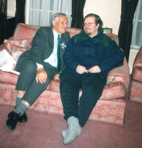 Photo of 2 men sitting on a couch