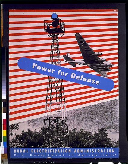 This image is a vintage poster featuring bold, graphic design elements with patriotic symbolism. It displays a searchlight tower and an airplane in the foreground against a background of red and white stripes reminiscent of American flags. A large blue banner overlays part of the scene with the text "Power for Defense." The bottom portion of the poster includes additional information: it states that this image is associated with the Rural Electrification Administration, which was under the U.S. Department of Agriculture between 1940 and 1950. This historical context suggests a connection to wartime efforts or national defense initiatives during World War II era America.