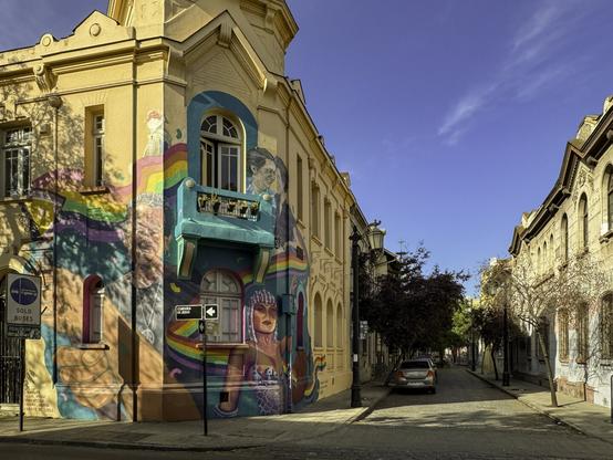 Street corner with yellow-colored buildings with murals