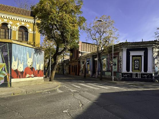 Street corner with small brick buildings and colorful murals