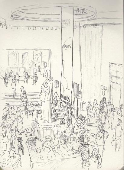 Black and white pen drawing. It's a large space with a very high ceiling, on the ground there's almost a circle of tables of exhibitors and a number of people around, there's a few tables to the sides as well. On the middle there's a big statue of a woman holding an open book and there's a big banner hanging all the way from a big circular opening on the middle of the first floor. The back wall opens to another space where there's also a couple artists with their work and visitors.