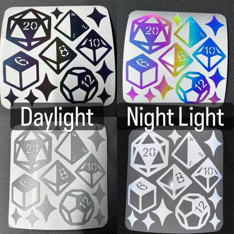 A composite photo of a reflective stickers sheet in both silver/white and black/rainbow vinyl. The material is retro reflective and is very visible in headlights. The left side of the image shows the stickers in normal daylight, the right side with a flash. The stickers themselves are several different dice (d4, d6, d8, d12, d20) and a bunch of diamond-ish sparkles.