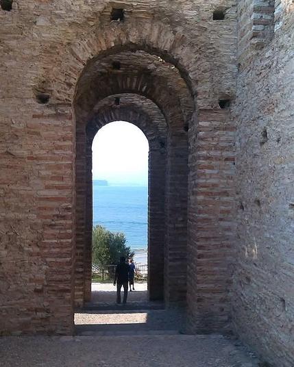 Ein Mann steht unter einem Torbogen der gut 5 mal so hoch ist wie er selbst der aber sehr schmal ist.