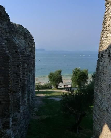 Blick Zeichen gigantischen verfallenen Ruinenstücken direkt aufs Wasser des blauen Gardasees.
