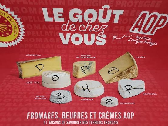 Photographie d'une affiche dans le métro, une publicité pour des différentes variétés de fromage AOP a été taguée au feutre de manière qu'il y a une lettre sur chaque morceau de fromage photographiée.