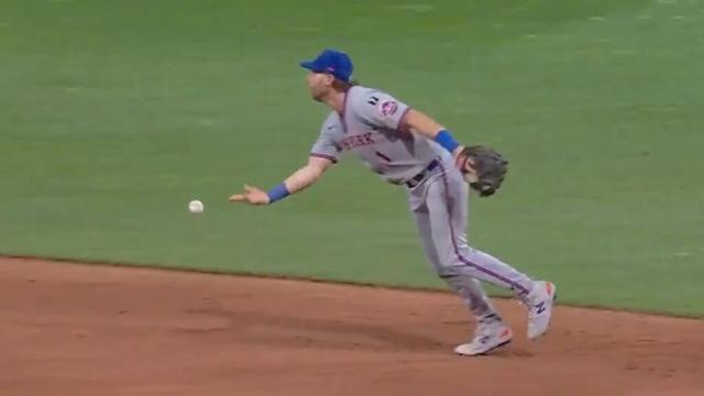 Jeff McNeil throwing the ball underhanded