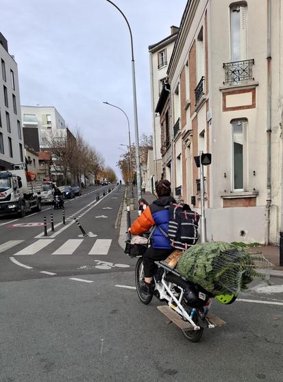 Place François Mitetterrand, cyclistes sur un longtail, un sapin sur le porte bagages