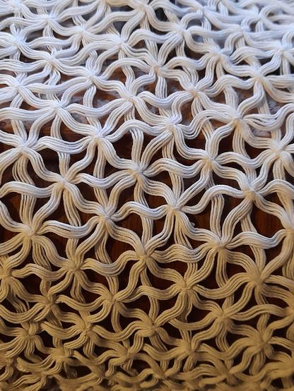 Structure of white threads connected in a star-like or floral pattern. I don't know how it was made.