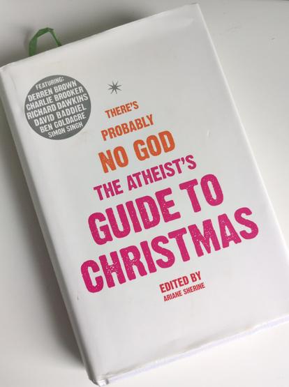 We have the front of a hardbook cover. It has a white background with a small silver star at the top. The following words in orange and red are formed like a Christmas Tree: 'There's probably no God. The Atheist's Guide to Christmas.'