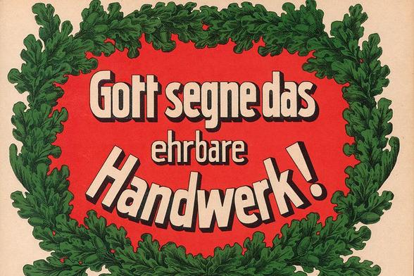 Historisch: Der Sinnspruch "Gott segne das ehrbare Handwerk!" auf einem von Eichenlaub umrandeten roten Hintergrund.