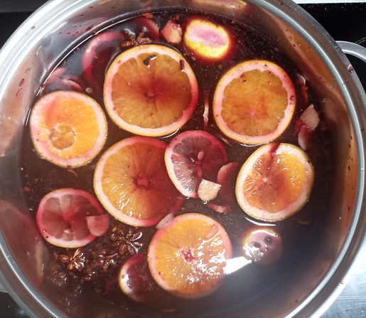 Der Wein mit Gewürzen und Zitrusfrüchten in einem großen Topf