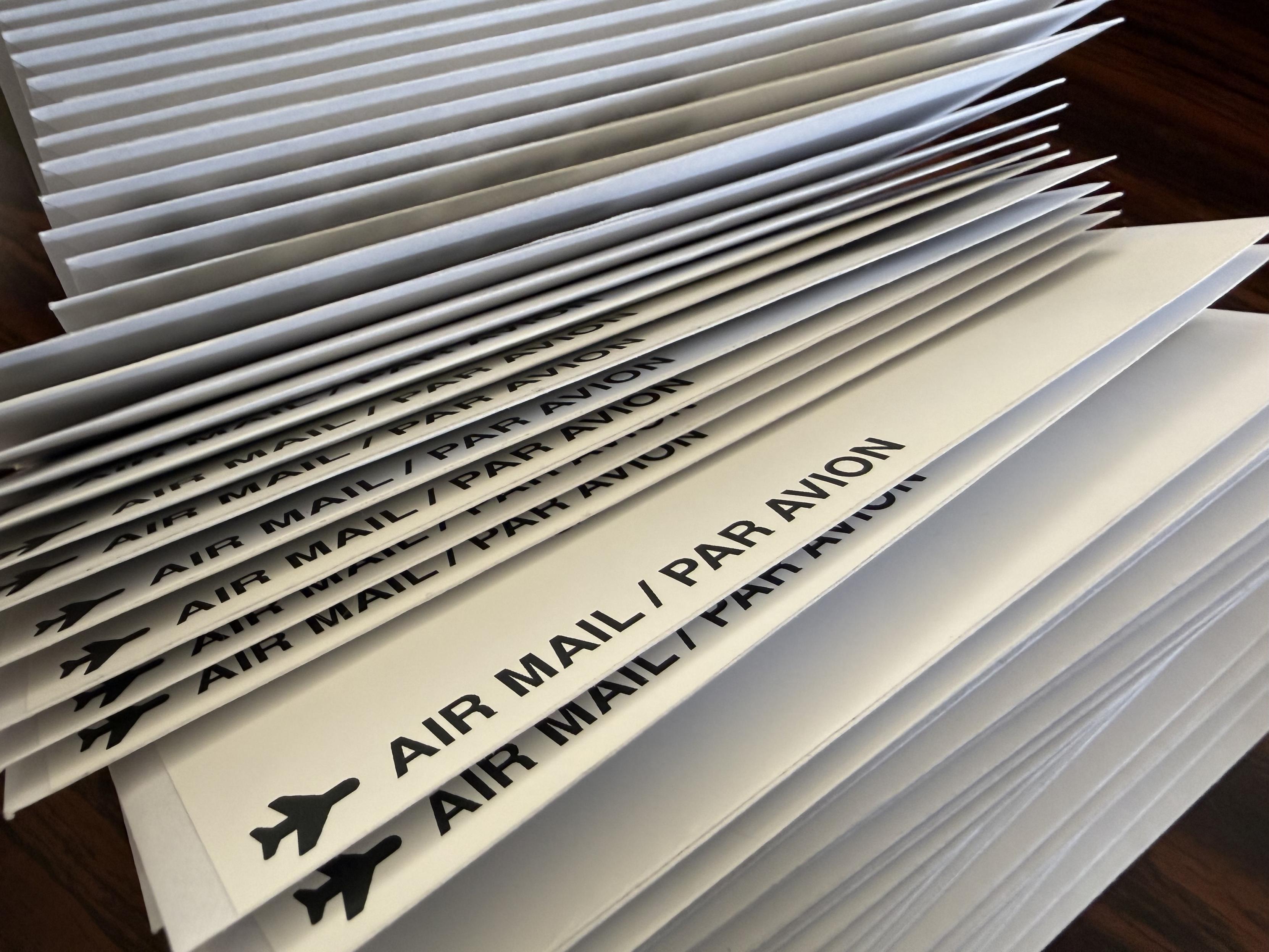 Side view of whole bunch of envelopes, many of which are marked “AIR MAIL / PAR AVION”