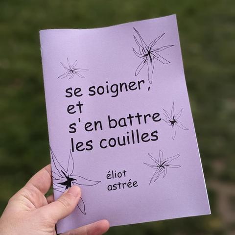 le fanzine tenu en main. On voit la couverture mauve, le titre et des fleurs en noirs et blancs un peu abstraites.