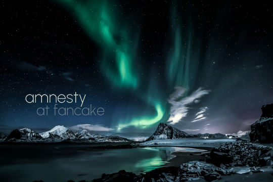 Photograph of the aurora borealis taken in Norway, text: Amnesty, at Fancake. The northern lights are a bright green scribble that stretches over the horizon, along a snowy mountain ridge, and up into the starry night sky.