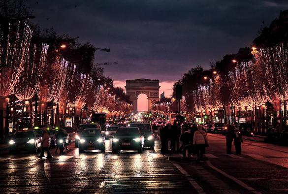 Blick entlang der Avenue des Champs Élysées in Richtung Arc de Triomphe. Es ist kurz nach Sonnenuntergang und die Adventsbeleuchtung erstrahlt.