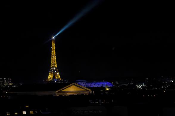 Der Eiffelturn erstrahlt bei Nacht. Zu jeder vollen Stunde funkelt er eine Weile.