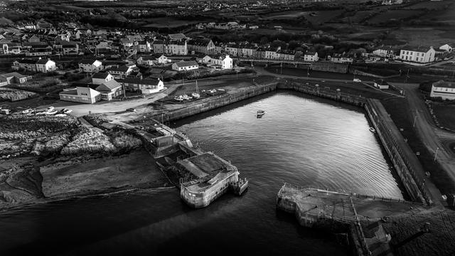 Aerial Monochrome shot over small harbour and town