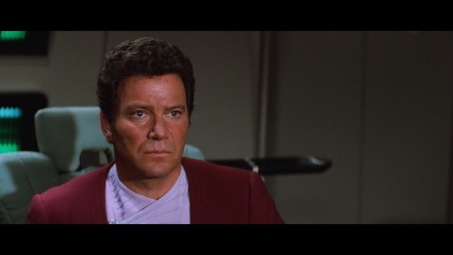 A shot from Star Trek III: The Search for Spock showing a close-up of an emotional Kirk sitting in the Captain's chair on the bridge of the Enterprise.