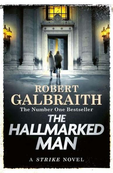 Buchcover von «The Hallmarked Man» von Robert Galbraith: Zwei Personen stehen vor einem beleuchteten Gebäude mit Säulen.