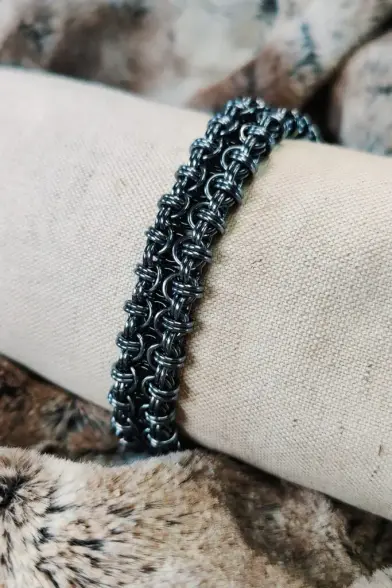 Bracelet en maille réalisé dans un motif relativement plat et dont les entrelas m'évoquent des constructions gothiques. Ici, le bracelet est réalisé en métal foncé.