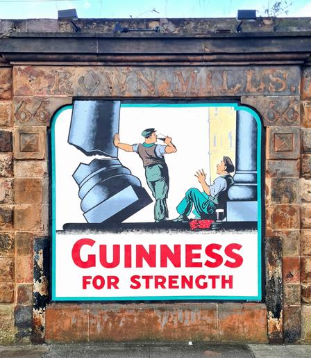 An old Guinness advert painted as a mural on a Glasgow building.